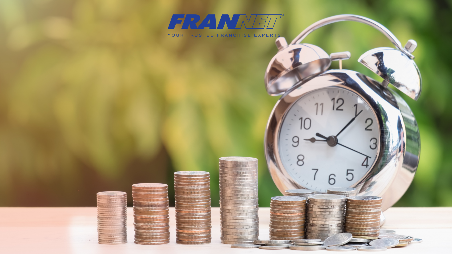 Stacks of coins with alarm clock next to it