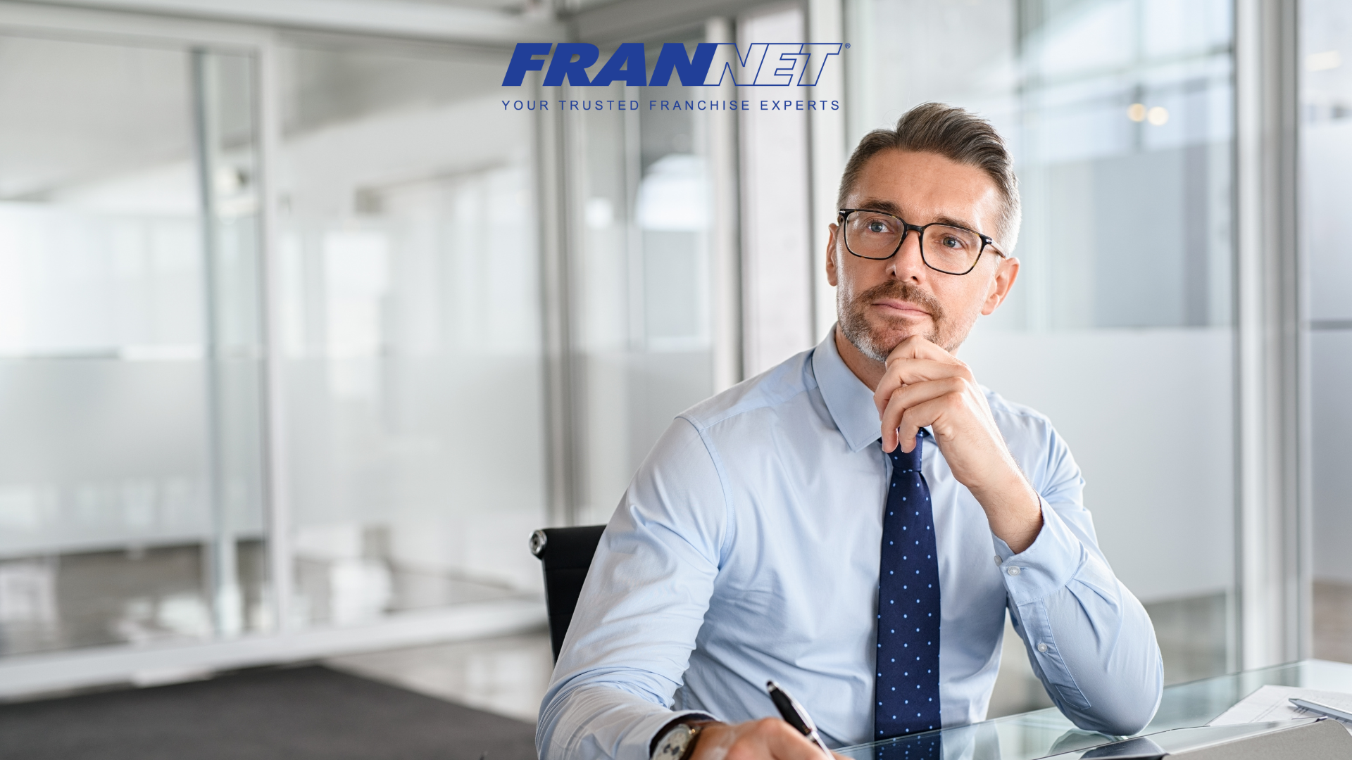Man sitting at desk thinking about how to choose a franchise