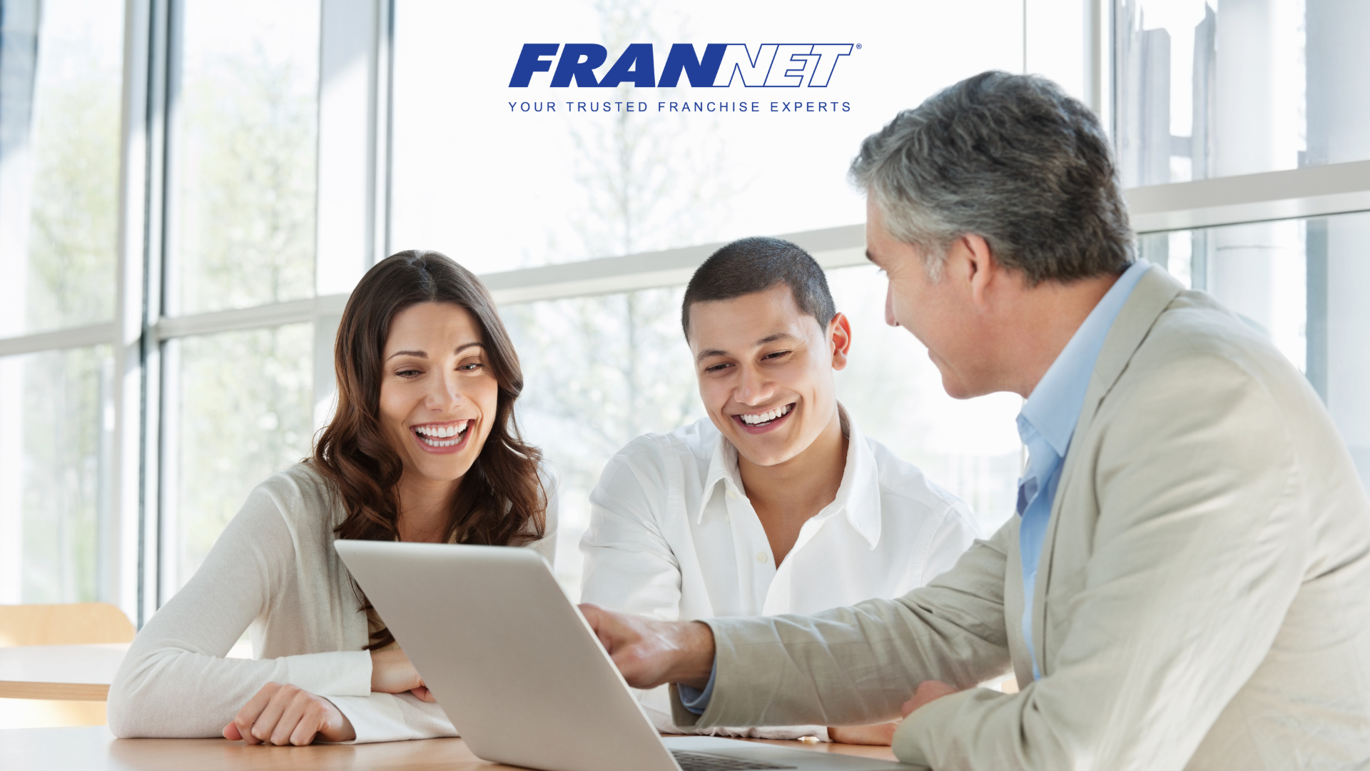 Man using a laptop and consulting in-person with couple