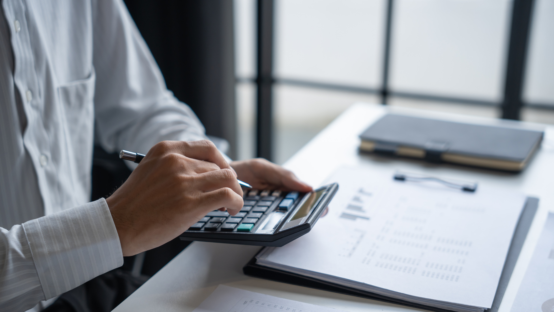 Man and calculator representing franchise financing